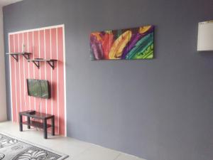 a painting hanging on a wall next to a table at NAUFAL MUSLIM'S HOMESTAY in Cameron Highlands