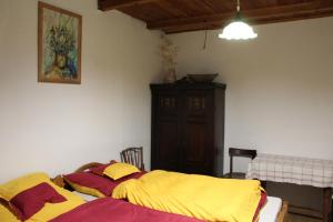 sypialnia z łóżkiem z żółtą i czerwoną pościelą w obiekcie Csengettyűs Vendégház w mieście Cered