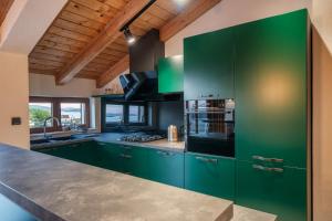 a kitchen with green cabinets and a counter top at Nomad Luxury Villa in Vodice