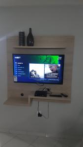 TV de pantalla plana en una estantería de madera en Seu AP 811, en Maceió