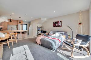 a bedroom with a bed and a table and a kitchen at Greenwich Townhouse with Parking and Air-Con in Auckland