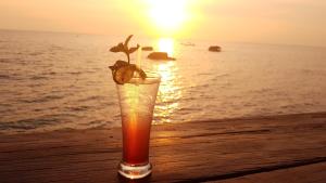 a drink on the beach with the sunset in the background at Free Beach Resort in Phú Quốc