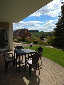 einen Tisch und Stühle auf einer Terrasse mit Aussicht in der Unterkunft Amy's Apartment, relax and enjoy in Bonndorf im Schwarzwald