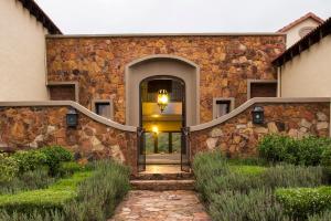 a stone house with a staircase leading to the front door at Mount High Luxury Country Estate in Lydenburg