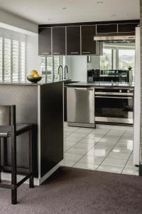 a kitchen with black and stainless steel appliances at Bolton Hotel in Wellington