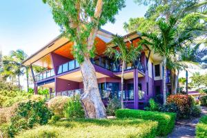 a purple house with palm trees in front of it at Anchorage in Hamilton Island