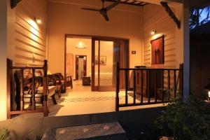 a house with a balcony with a door to a room at Puri Mas Boutique Resort & Spa in Senggigi
