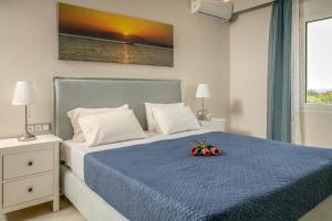 um quarto com uma cama azul com flores em Evgenia Apartment em Lerápetra
