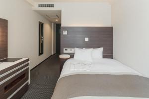 um quarto de hotel com uma cama com dois copos em Kusatsu Estopia Hotel em Kusatsu