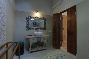 a bathroom with a sink and a mirror on the wall at Puri Mas Boutique Resort & Spa in Senggigi