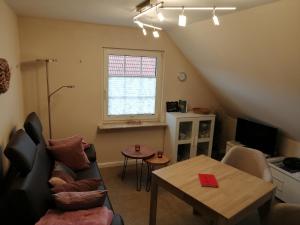 a living room with a couch and a table at Ferienwohnung Hafenliebe-Greetsiel in Greetsiel
