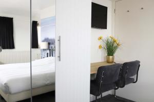 
a hotel room with a bed and a chair at Heeren van Noortwyck in Noordwijk aan Zee
