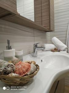 凱里翁的住宿－Villa Tramonto Keri，浴室水槽上装有一篮子贝壳