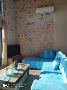 凱里翁的住宿－Villa Tramonto Keri，客厅设有蓝色的沙发和石墙