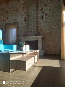 凱里翁的住宿－Villa Tramonto Keri，客厅配有桌子和石墙