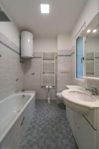 uma casa de banho com 2 lavatórios, uma banheira e um WC. em Apartment Duomo em Bolzano