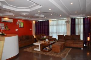 a living room with brown furniture and red walls at Hotel Bodh Vilas in Bodh Gaya