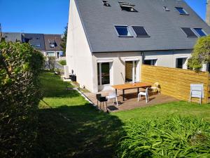 um quintal com uma mesa e cadeiras e uma casa em Les bulles champenoises em Châtillon-sur-Marne