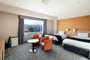 a hotel room with two beds and a window at Sapporo Excel Hotel Tokyu in Sapporo