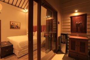 a bedroom with a bed and a mirror at Puri Mas Boutique Resort & Spa in Senggigi
