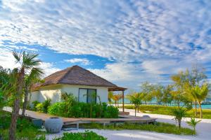 une maison sur la plage avec un ciel nuageux dans l'établissement The Royal Sands Koh Rong, à Koh Rong