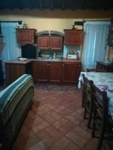 kuchnia z drewnianymi szafkami i stołem z krzesłami w obiekcie Apartment Luzi w mieście Urbania