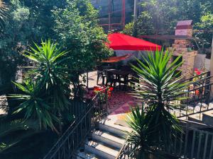 a patio with a table and chairs and palm trees at Mandarin in Makhinjauri