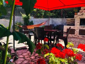 a group of chairs and tables with an umbrella and flowers at Mandarin in Makhinjauri
