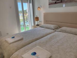 two beds sitting next to each other in a bedroom at Sea Club Apartments in Cala Millor