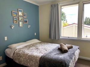 a bedroom with a bed and a large window at Tailor Made Tekapo Accommodation - Guesthouse & Hostel in Lake Tekapo
