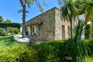 a stone house with palm trees in front of it at Hotel Club Astor in Ugento