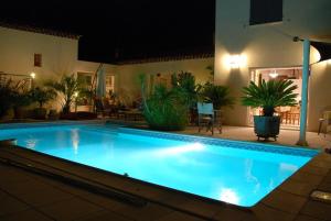 uma grande piscina à noite numa casa em ChambreStudio bord de mer, Piscine et SPA em Six-Fours-les-Plages