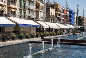 a fountain in the middle of a street with buildings at Tarragona Ciudad, El Serrallo AP-3 in Tarragona