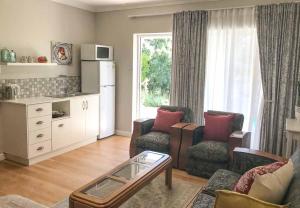 a living room with a couch and two chairs at Protea Suite in Cape Town
