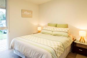 ein Schlafzimmer mit einem Bett mit zwei Lampen und einem Fenster in der Unterkunft Sandy point hideaway in Sandy Point