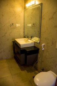 a bathroom with a sink and a mirror and a toilet at M Hotel Thamel-Kathmandu in Kathmandu