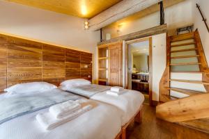 um quarto com uma cama grande e uma parede de madeira em Chalet Hotel Du Fornet em Val dʼIsère