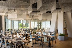 a restaurant with tables and chairs in a room at Maistra Select Family Hotel Amarin in Rovinj