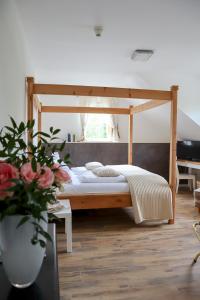 a bed with a wooden canopy in a room at Hotel Gut Moschenhof in Düsseldorf