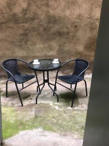 czarny stół i dwa krzesła z kubkami na nim w obiekcie Apartment Old town w mieście Tbilisi City