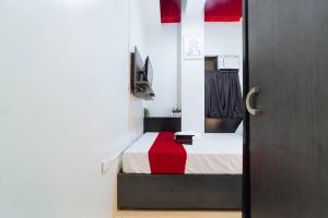 um quarto com uma cama com um cobertor vermelho e branco em RedDoorz near G Mall Bajada- Multiple Use Hotel em Davao
