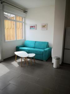 a living room with a blue couch and a table at studio en plein centre ville à 8 minutes de l'océan in Le Porge