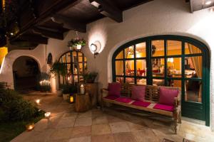 a patio with a bench with pink pillows on it at bei Max - Hotel & Traditionshaus in Sankt Leonhard im Pitztal +49 photos