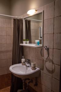 uma casa de banho com um lavatório e um espelho em Maltezos Rooms em Methana