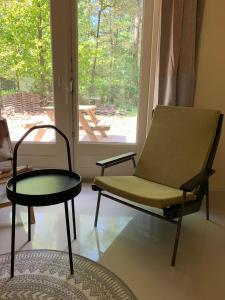 Habitación con silla, mesa y ventana en Wina Boshuisje Veluwe, en Otterlo