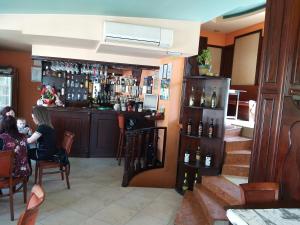 a woman sitting at a bar in a restaurant at ХОТЕЛ НИК in Asenovgrad