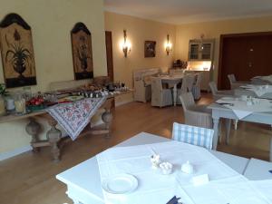 uma sala de jantar com mesas e cadeiras brancas em Gästehaus am Alten Hafen em Jork