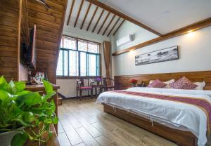 1 dormitorio con 1 cama grande en una habitación con paredes de madera en W_Smart Motel Superior Hongcun en Yi