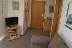 a living room with a couch and a tv at Ferienwohnung auf der Sonneninsel in Fehmarn