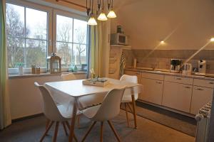 a kitchen with a white table and chairs in a room at Ferienwohnung auf der Sonneninsel in Fehmarn